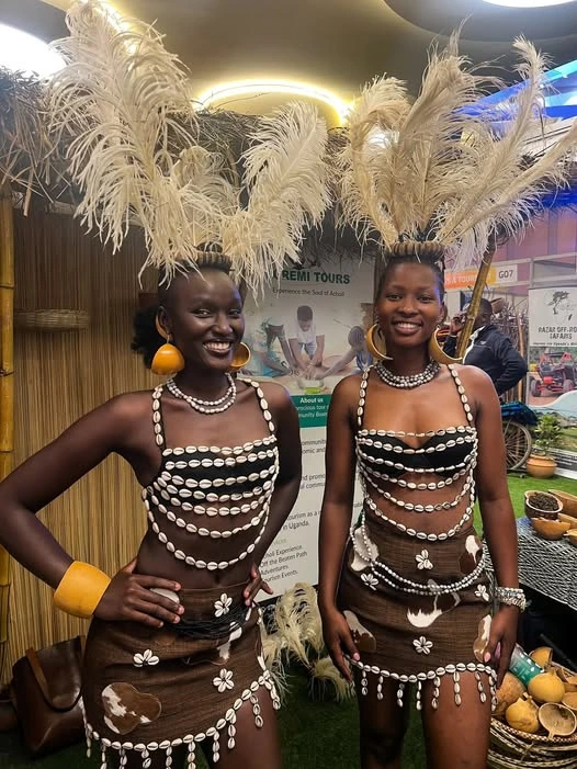 Two women in beaded traditional attire with feathered headdresses